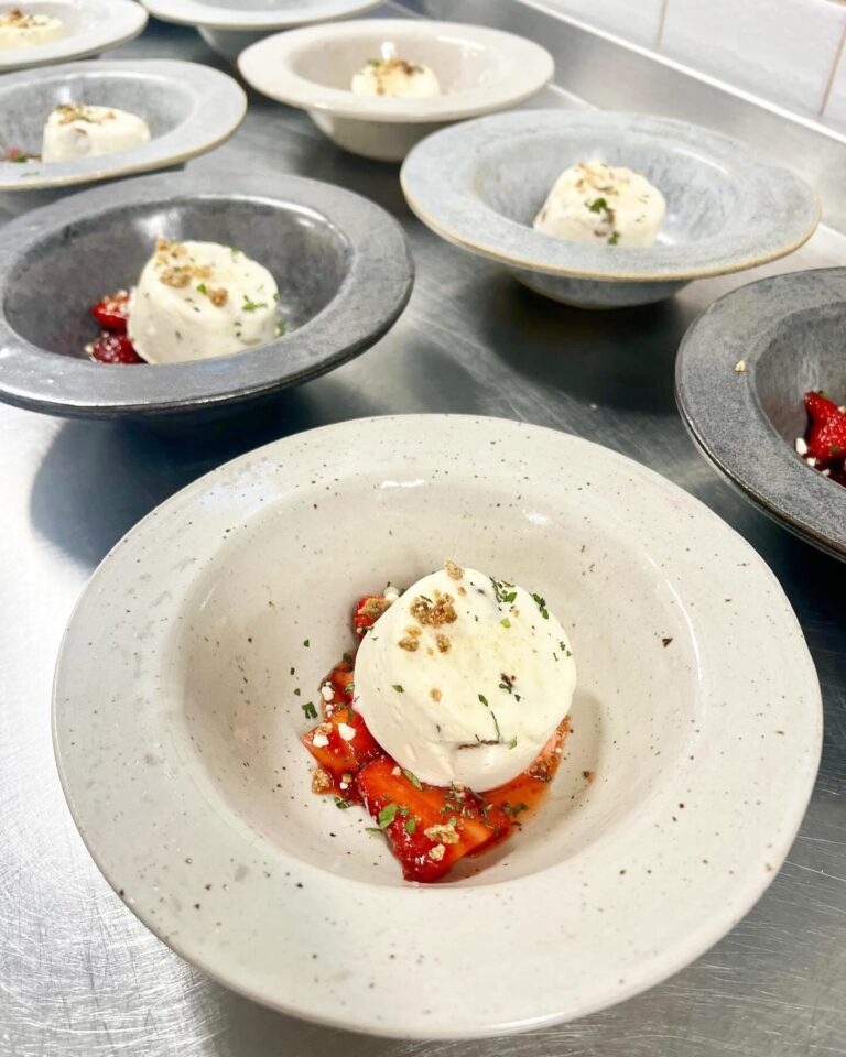 Parfait på marinerade jordgubbar toppad med crumble i keramikskålar