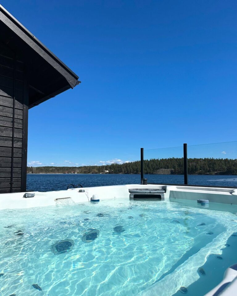 Bubblande jacuzzi på altanen med sjön Sommen och skogen i bakgrunden