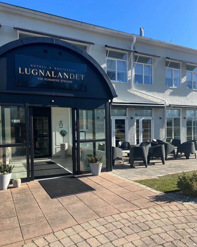 Lugnalandets huvudentré med skylt och uteservering en solig vårdag
