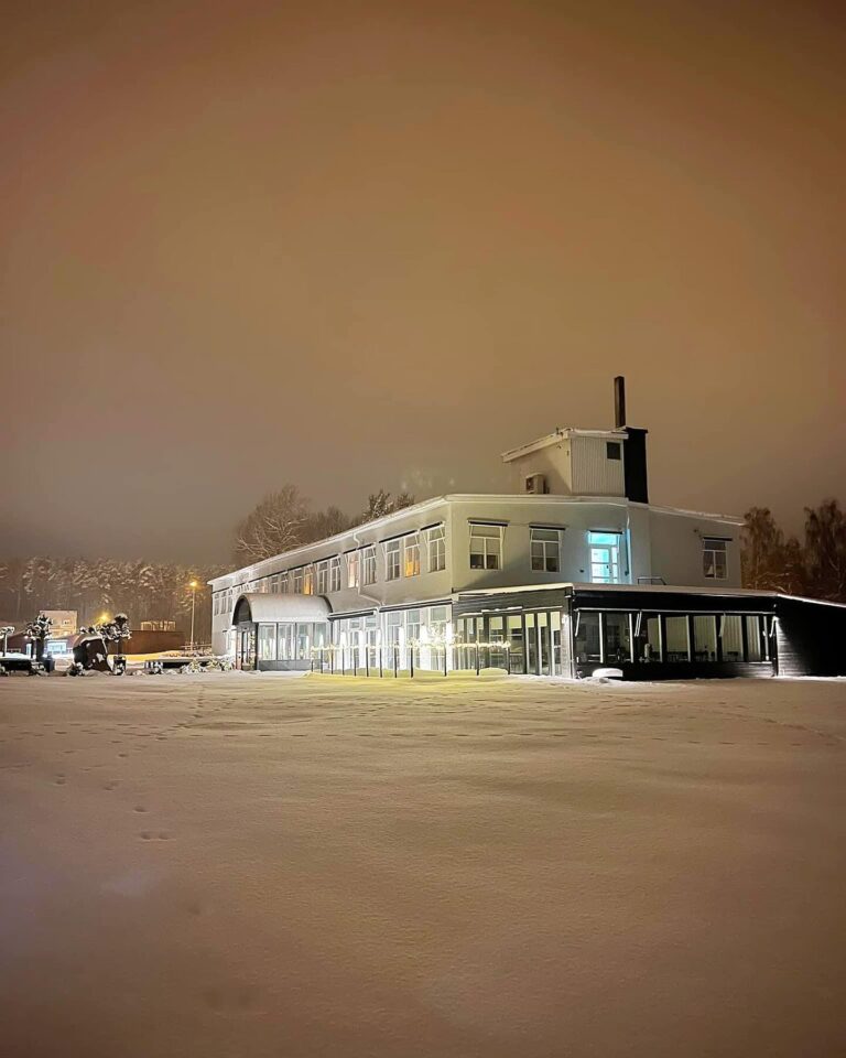 Lugnalandets byggnad med upplysta fönster en snötäckt vinterkväll